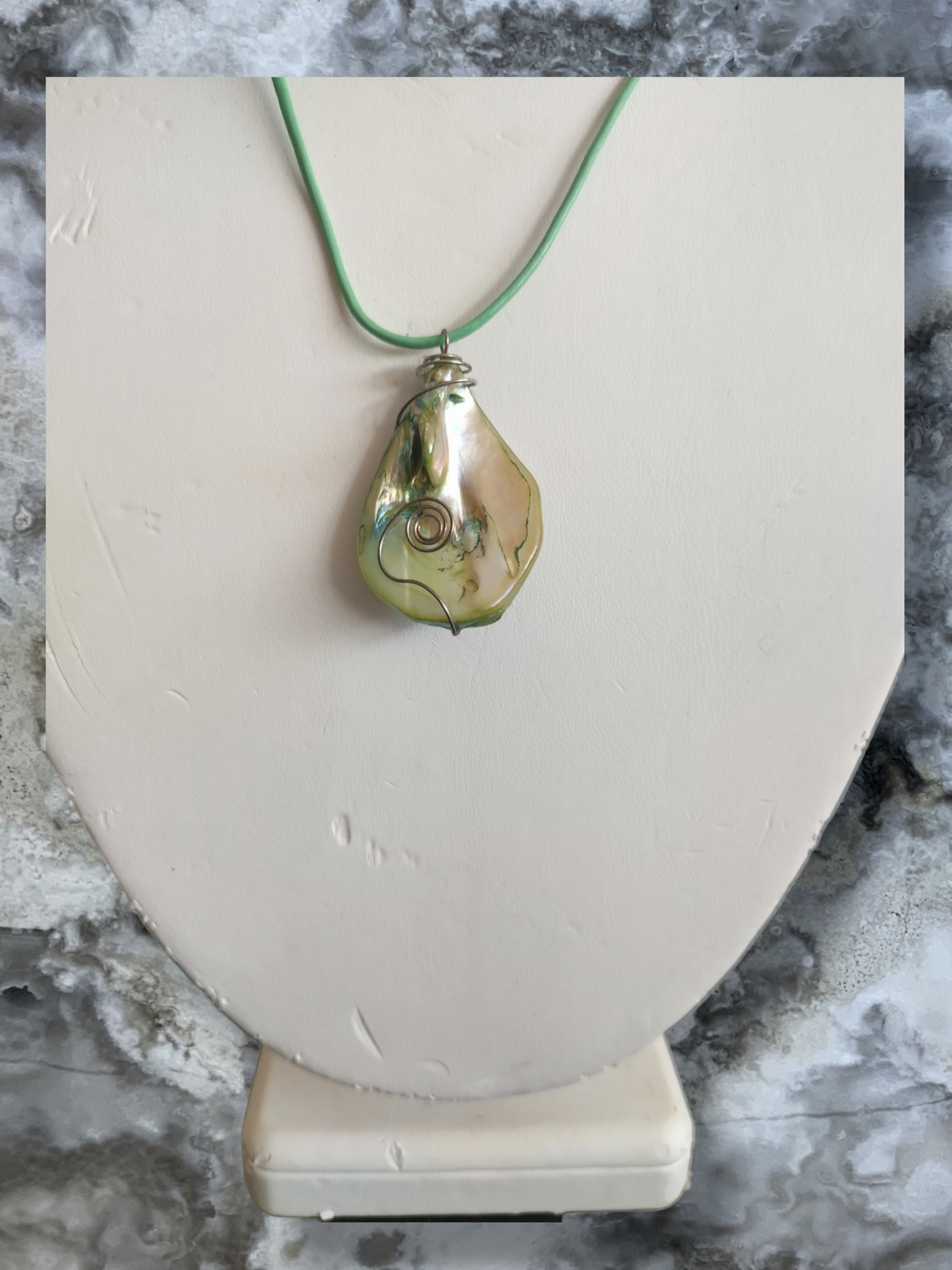 Mother of pearl pendant on an adjustable leather cord.