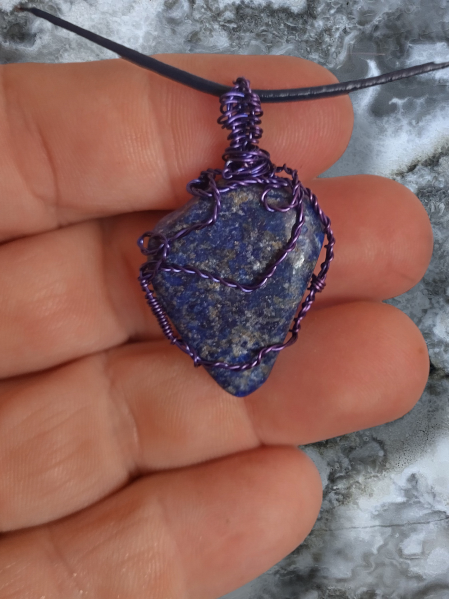 Lapis lazuli hand wrapped pendant on an adjustable leather cord.