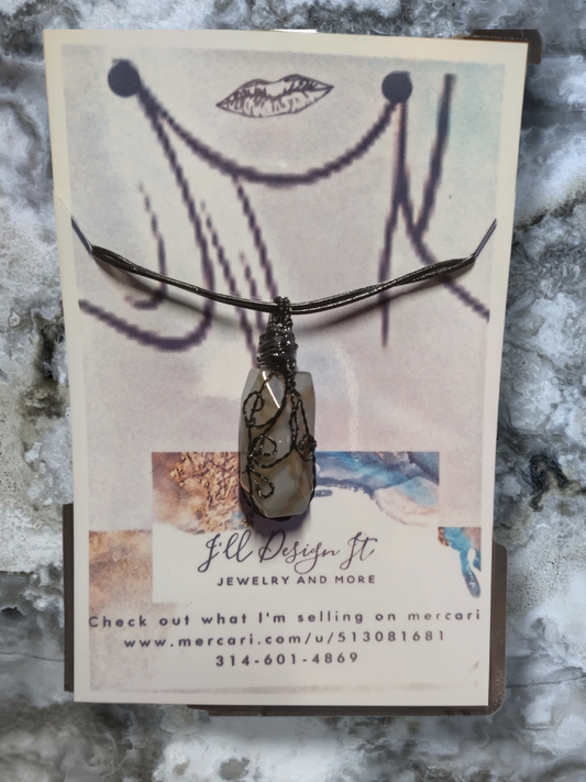 Agate hand wrapped pendant on an adjustable leather cord necklace.