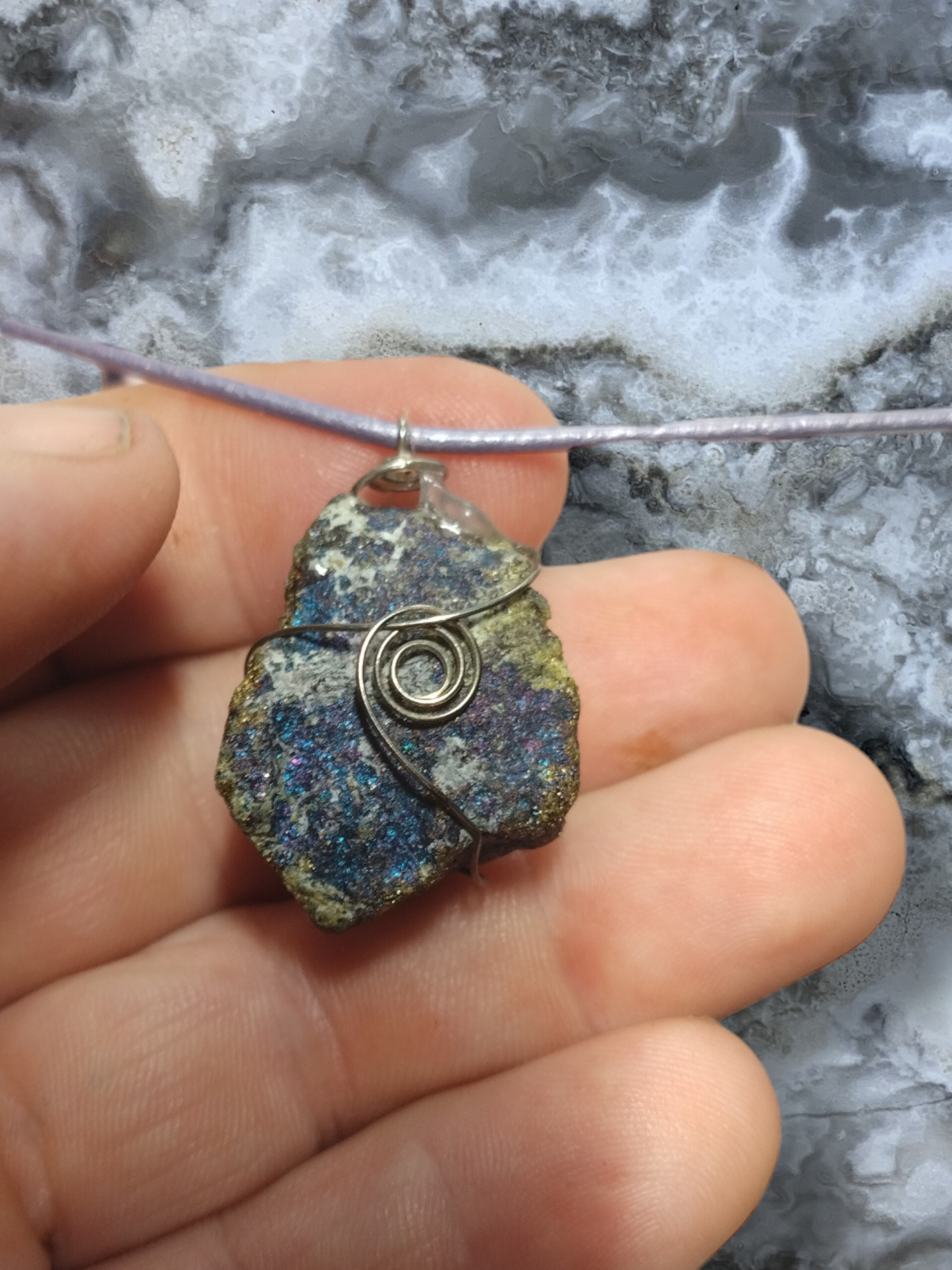 Wire wrapped peacock ore pendant on an adjustable leather cord necklace.