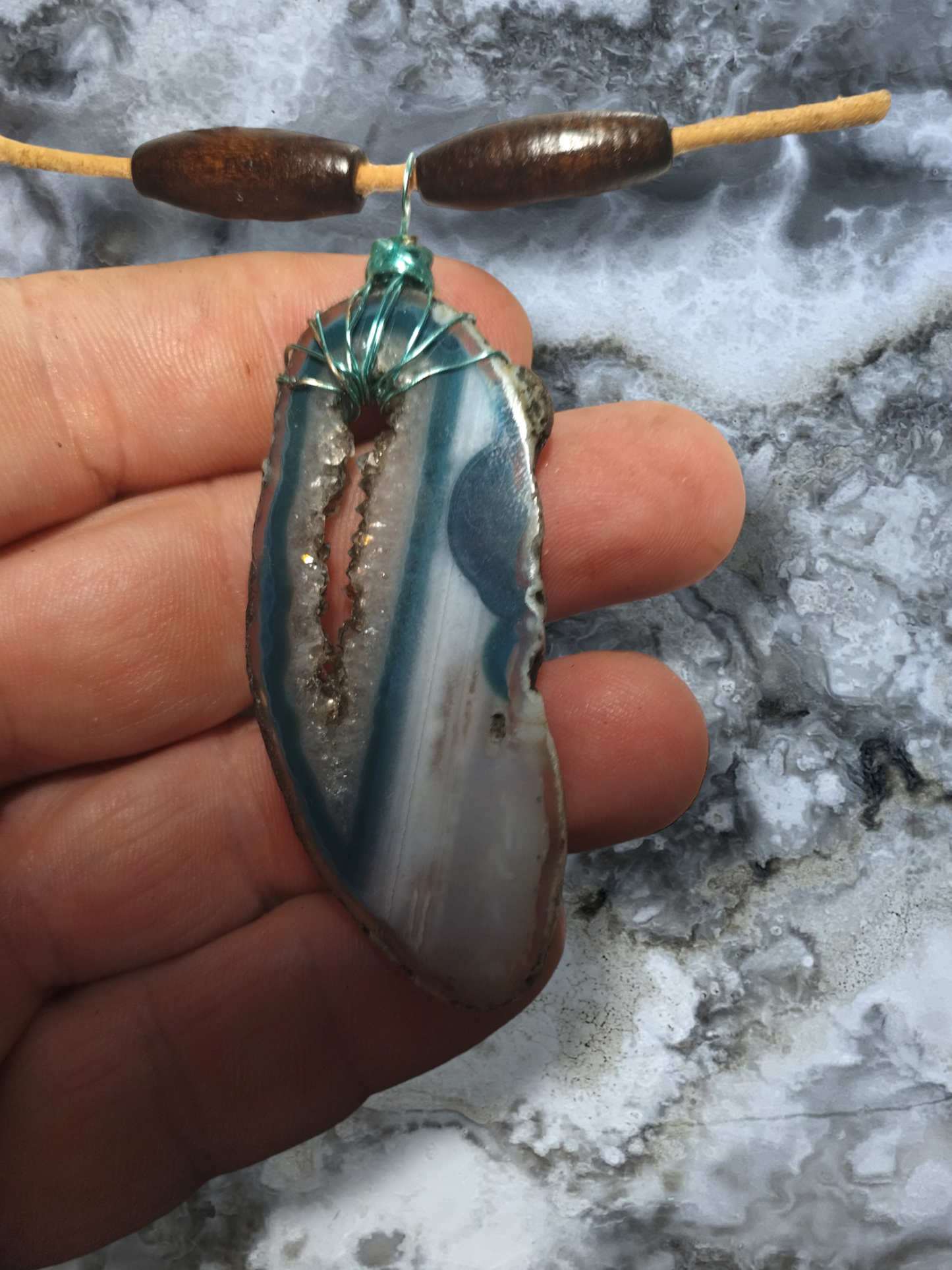 Dyed agate slice pendant on an adjustable leather cord necklace.