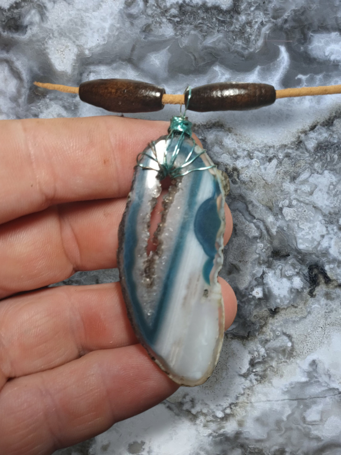 Dyed agate slice pendant on an adjustable leather cord necklace.