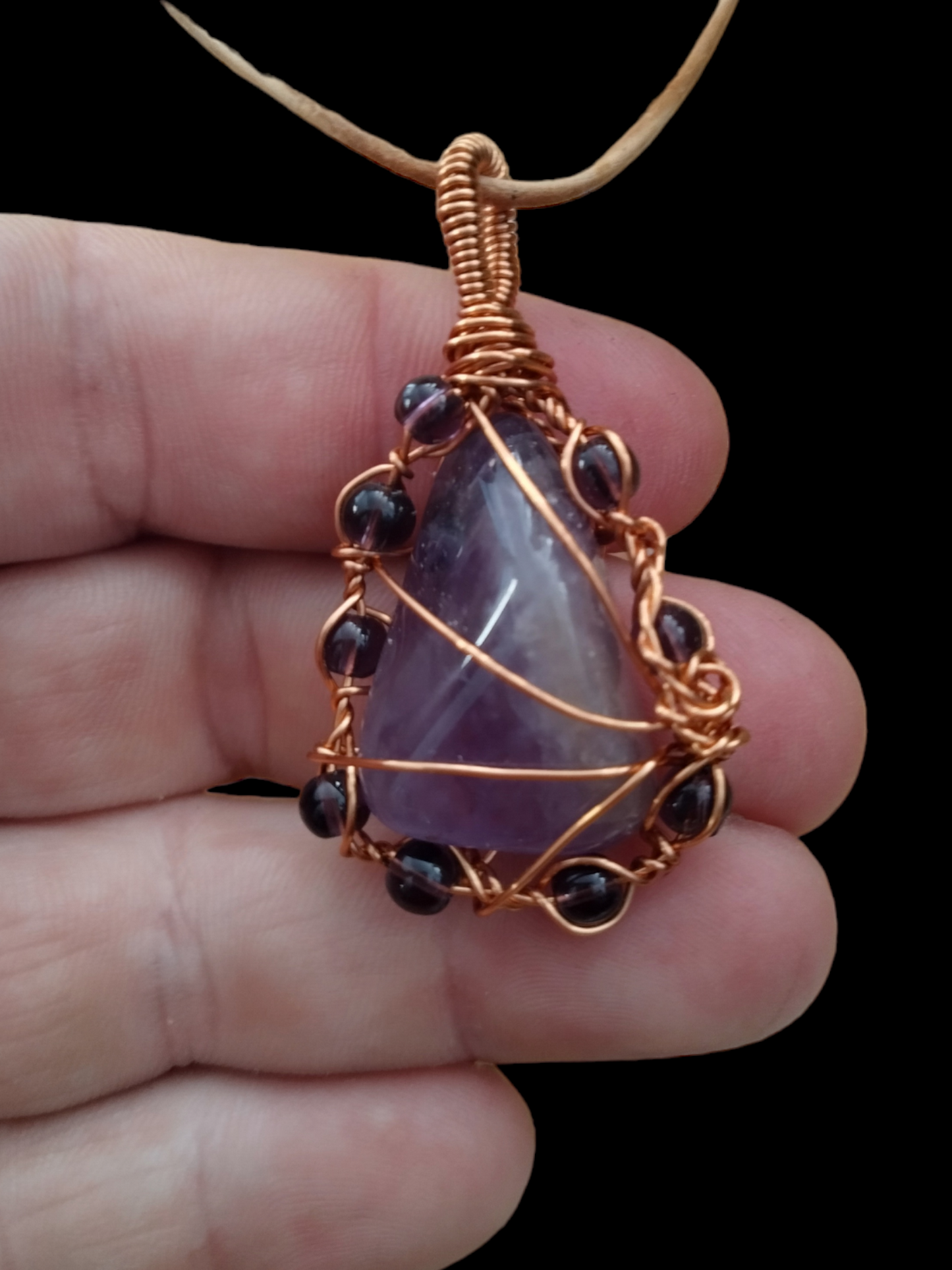 Handmade wired wrapped amethyst stone on an adjustable leather cord.